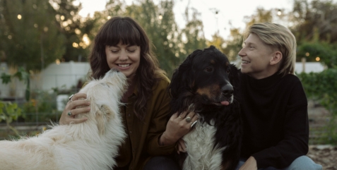 two people with dogs in a garden